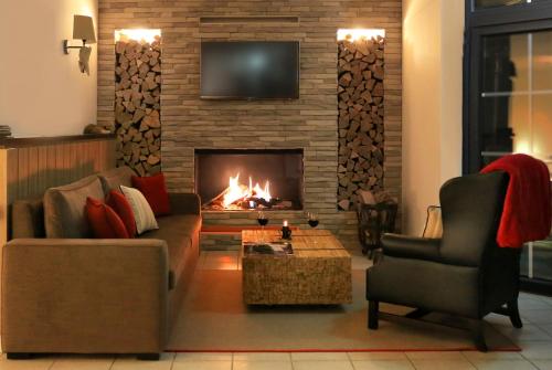 奥斯赛拜-屈隆斯博恩Wittenbeck Resort的客厅设有壁炉、沙发和椅子