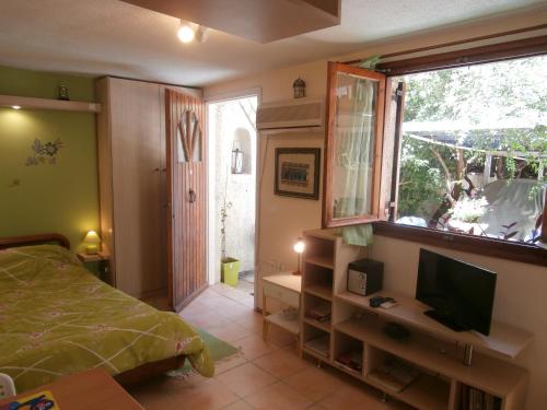 雅典雅典格利法达一室公寓的一间卧室配有一张床、一台电视和一个窗口