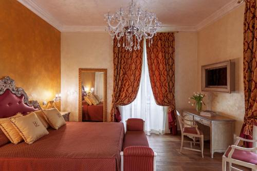 维罗纳帝国旅馆的一间卧室配有一张红色的床和吊灯。