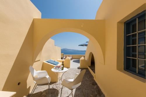 伊亚Horizon Aeifos Suites的阳台享有房屋的景致,配有桌椅