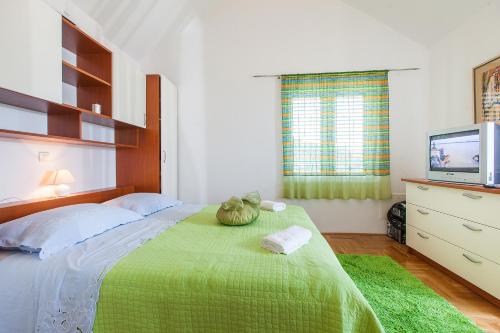 图彻皮Villa Lora的一间卧室配有一张带绿毯的床和一台电视