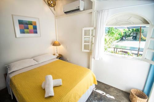 里约热内卢伊帕奈玛海滩别墅酒店的一间卧室设有黄色的床和窗户。