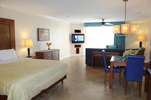 棕榈滩迪威一室公寓度假村的一间卧室配有一张床、一张桌子和一张沙发