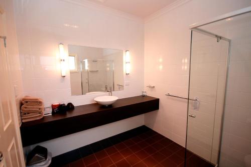 怀阿拉桑丹莫特酒店的浴室配有盥洗盆和带镜子的淋浴