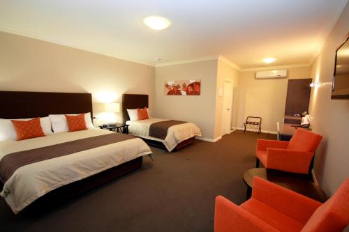 怀阿拉桑丹莫特酒店的酒店客房,配有两张床和椅子