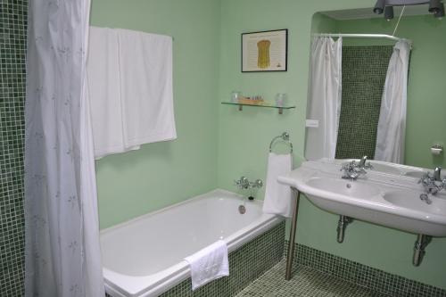Pozal de Gallinas波萨达瑞尔德尔派纳旅馆的带浴缸、水槽和浴缸的浴室