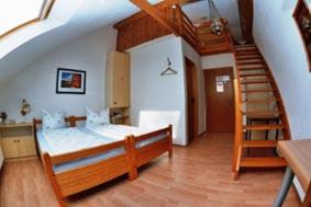 布雷根茨林德宾馆的一间卧室设有一张床和一个螺旋楼梯