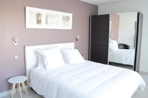 维尔特·圣丹尼斯Chez Jojo & Cassi的卧室配有白色的床和镜子