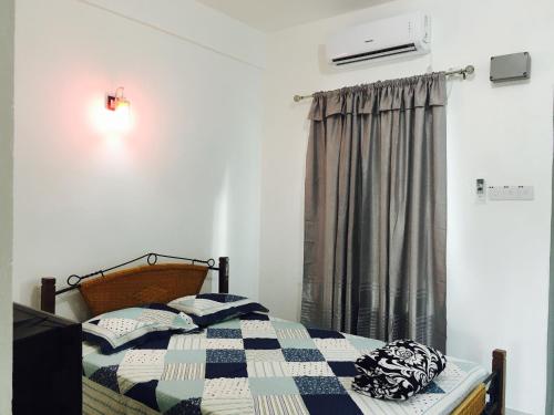 瓜埠拉亚旅馆的一间卧室配有一张带 ⁇ 子毯子的床