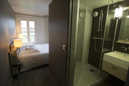 索姆河畔的圣瓦列里卡普霍尔努旅馆的浴室设有床铺和玻璃淋浴间。