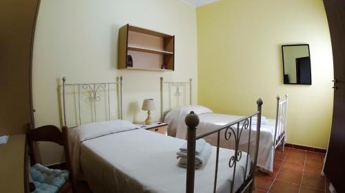 圣费尔迪南多Rosa Di Mare的一间卧室配有两张床和镜子