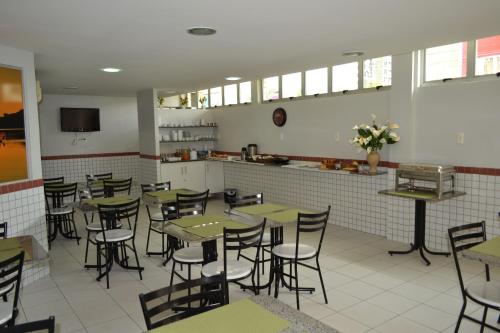 特雷西纳Hotel Ideal的一间带桌椅的餐厅和一间厨房