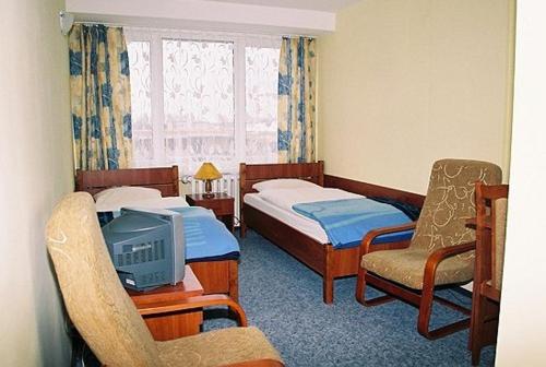 弗沃茨瓦韦克Hotel Kujawy的一间酒店客房,设有两张床和电视
