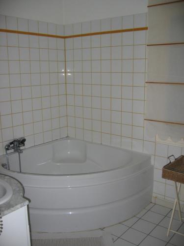 Saint-Branchs德帕奇莱旅馆的瓷砖浴室设有白色浴缸及水槽