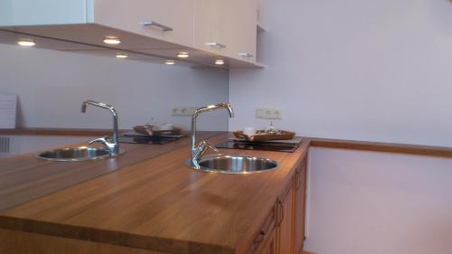 里加里加老城公寓的带木台面的厨房内的2个水槽