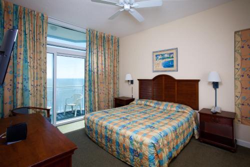默特尔比奇Holiday Sands at South Beach的一间卧室设有一张床和一个阳台的窗户。