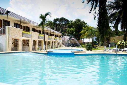 奥隆阿波苏比克大海度酒店的一座带喷泉的建筑前的游泳池