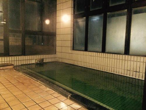 千曲市旬树庵柏屋传统日式旅馆的一座有窗户的建筑中的空游泳池