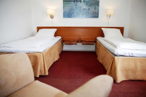 Eskilstrup赫耶穆勒汽车旅馆的一间设有两张床和红地毯的客房