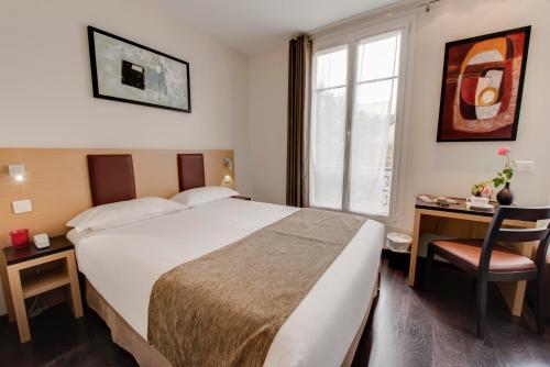 巴黎苏尔斯酒店的配有一张床、一张书桌和一扇窗户的酒店客房