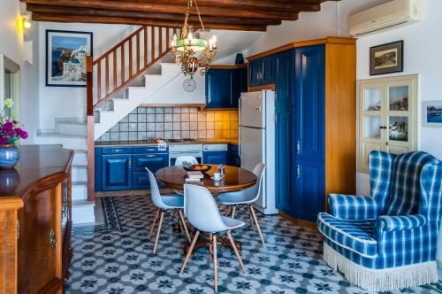 普拉卡米洛斯Nearchos House的厨房配有蓝色橱柜和桌椅