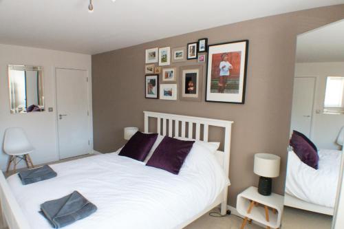 伦敦宽敞中央家庭公寓的卧室配有白色的床和镜子