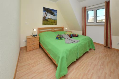 布雷格Ferienwohnung Generalsuite的一间卧室设有绿色的床、梳妆台和窗户。