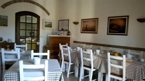 卡帕尔比奥Agriturismo Vallerana的用餐室配有白色的桌子和白色的椅子