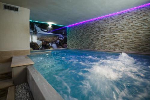 平佐洛Olympic regina hotel的一座带砖墙的大型室内游泳池