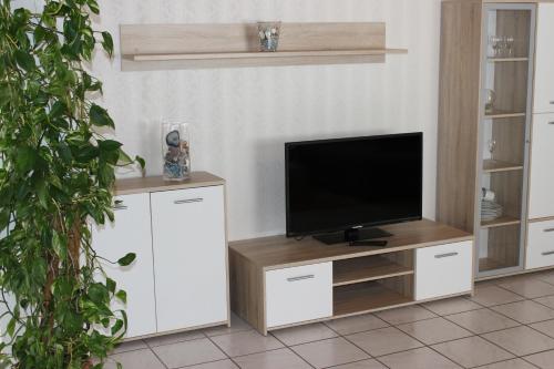巴特马林贝格安吉拉公寓的一间客厅,在白色娱乐中心配有电视