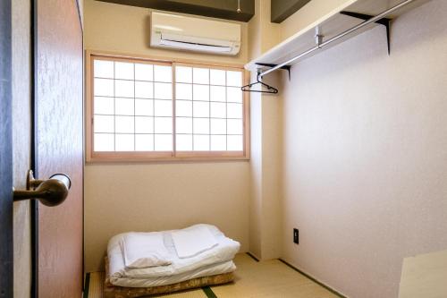 横滨横滨林会馆乡村旅馆的客房设有窗户和一张床