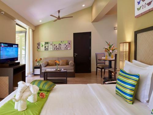 维拉杰佩特库格维拉杰佩特马辛德拉俱乐部度假村的一间卧室设有一张床和一间客厅。