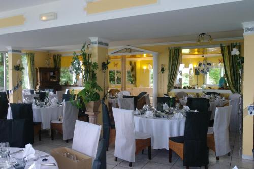 塞尔河畔维克圣克莱门特旅馆的一间设有白色桌椅的用餐室