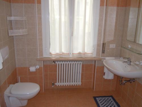 塔皮安诺Albergo Elvira的一间带卫生间、水槽和窗户的浴室