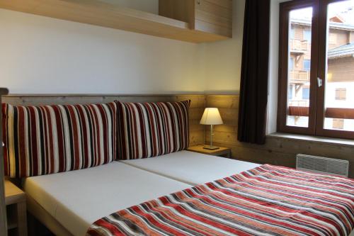 拉塔尼亚Résidence Britania Clés Blanches的一间卧室配有一张床,床上有条纹毯子