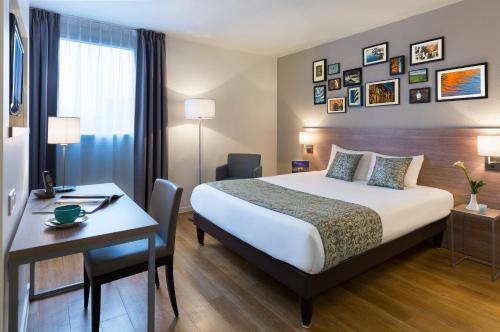 图卢兹馨乐庭图卢兹威尔逊酒店的配有一张床和一张书桌的酒店客房