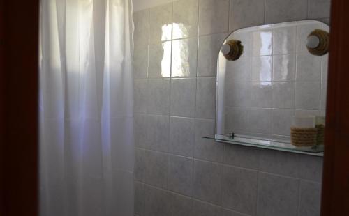 卡特瑞杜斯弗洛拉利亚公寓式酒店的浴室配有淋浴帘和镜子