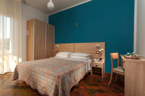 切塞纳蒂科Hotel Gattuccio的一间卧室设有一张床和蓝色的墙壁