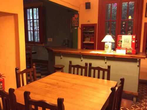 坦迪尔Casa Chango Hostel的一间带木桌和酒吧的用餐室
