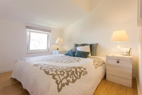 梅利迪什FLH Melides Beach House的白色的卧室设有床和窗户