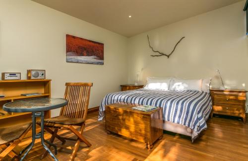 布伦海姆Misty River Retreat的一间卧室配有一张床、一张桌子和一张书桌
