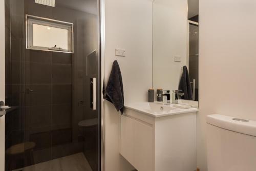 彭古因企鹅海滩度假屋的白色的浴室设有水槽和淋浴。