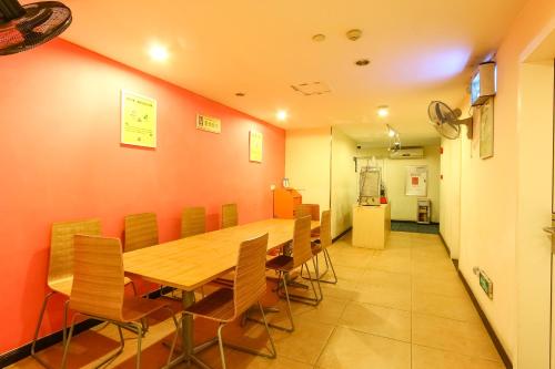 广州7天连锁酒店广州梅花园地铁站店的一间会议室,配有木桌和椅子