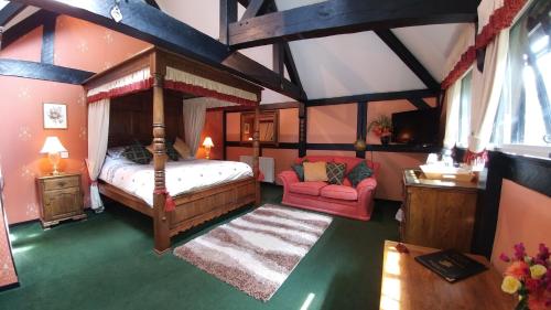 博格诺里吉斯奥德普瑞住宿加早餐旅馆的一间卧室配有天蓬床和红色沙发