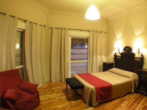 昆卡卡诺瓦斯旅馆的卧室配有床、椅子和窗户。