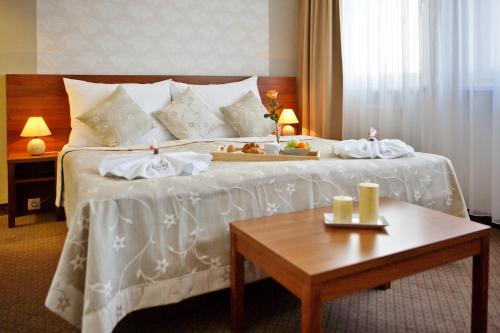 利普托斯基米库拉斯亚诺希克酒店的一间酒店客房,配有一张床铺,上面放着一个食物托盘