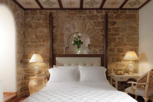 佛罗伦萨金塔温泉酒店的卧室配有白色的床和石墙