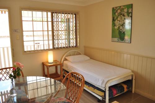 布里斯班伊斯拉公寓的小房间设有床和玻璃桌