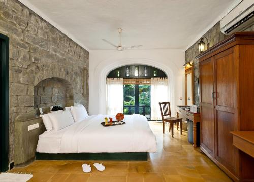 蒂鲁瓦纳马莱斯帕拉特鲁瓦纳玛莱度假酒店的一间卧室设有一张大床和石墙