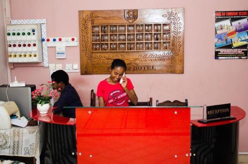马哈赞加Salama Hôtel Majunga的坐在桌子旁的女人在说手机